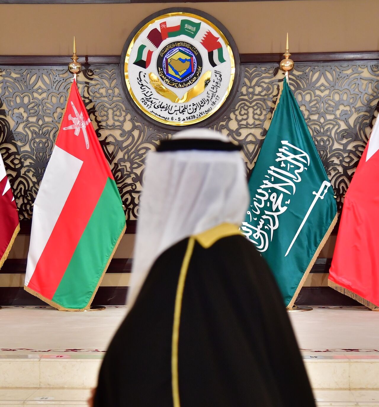 A man walks past the flags of the countries attending the Gulf Cooperation Council summit at Bayan palace in Kuwait City on Dec. 5, 2017.