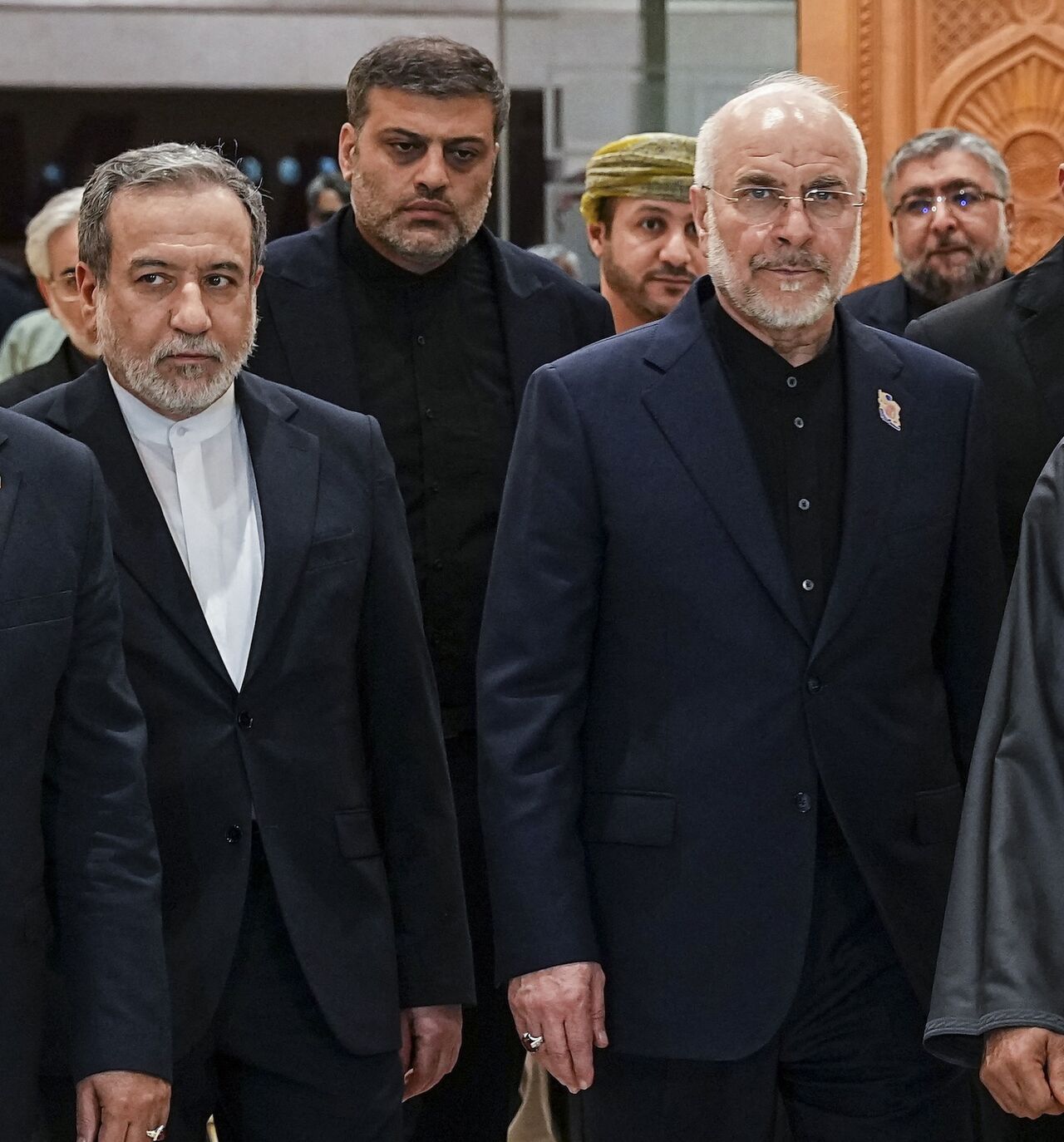 Iranian Foreign Minister Abbas Araghchi (2nd L), Iranian parliament speaker Mohammad Bagher Ghalibaf (2nd R) and Omani Foreign Minister Badr bin Hamad Al-Busaidi (R) walk inside a building in Muscat, Oman, on June 22, 2026. 
