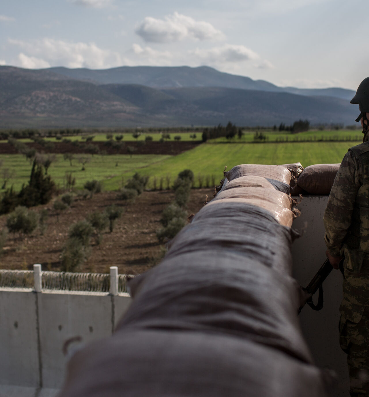 A Turkish soldier from the 1st Border Regiment Command looks out over the border wall to Syria during alert drills at a military outpost on the Turkey/Syria border on March 2, 2017 in Kilis, Turkey. 