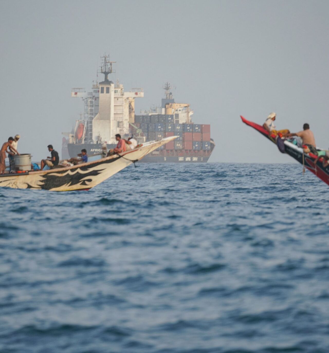 boats and a container ship near the Strait of Bab al-Mandeb