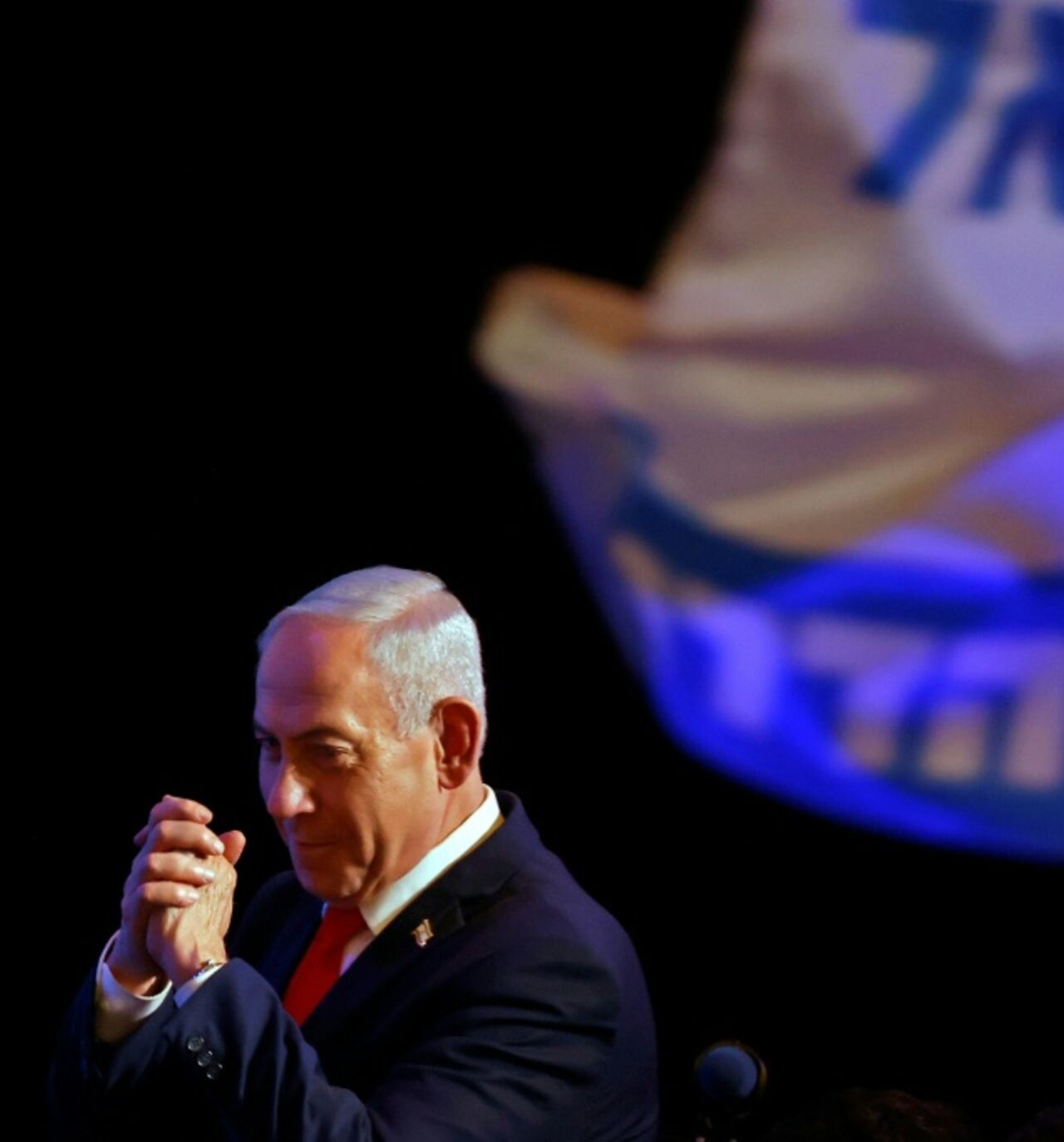 Israel's Prime Minister Benjamin Netanyahu gestures to his supporters at the election night rally after the first exit polls were announced, in Jerusalem