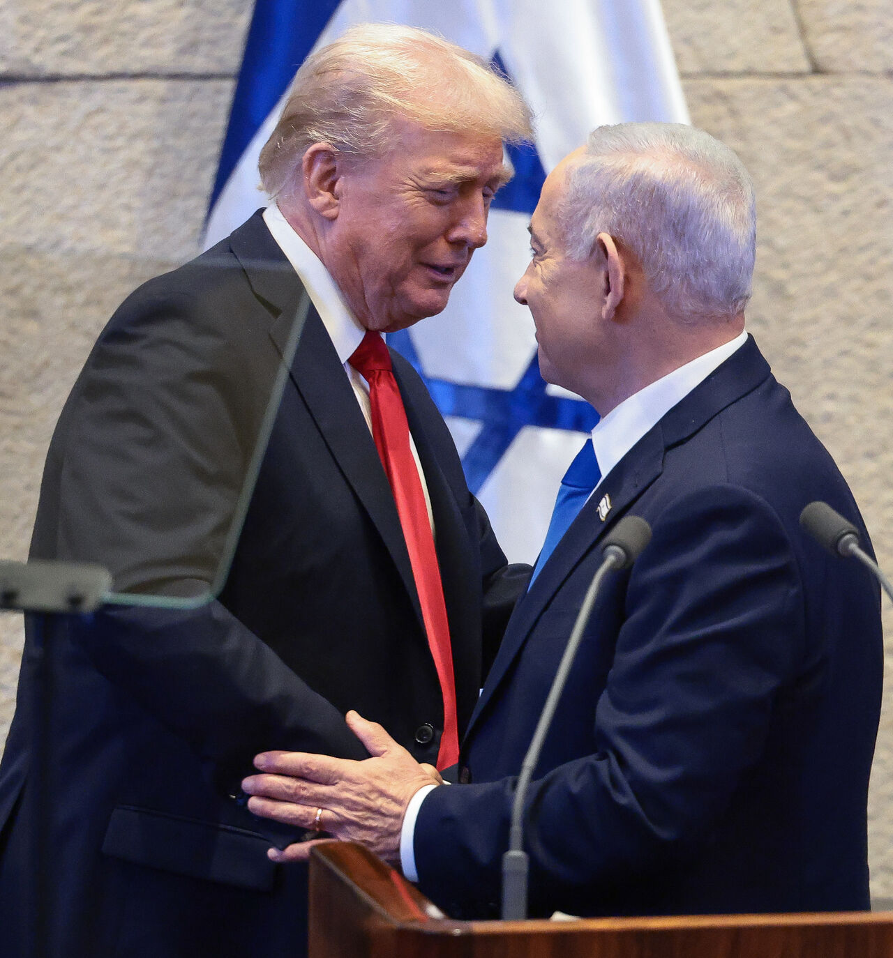 JERUSALEM - OCTOBER 13: U.S. President Donald Trump shakes hands and speaks with Israeli Prime Minister Benjamin Netanyahu at the Knesset, Israel's parliament, on the day of Trump's address on October 13, 2025 in Jerusalem. President Trump is visiting the country hours after Hamas released the remaining Israeli hostages captured on Oct. 7, 2023, part of a US-brokered ceasefire deal to end the war in Gaza. (Photo by Evelyn Hockstein - Pool/Getty Images)