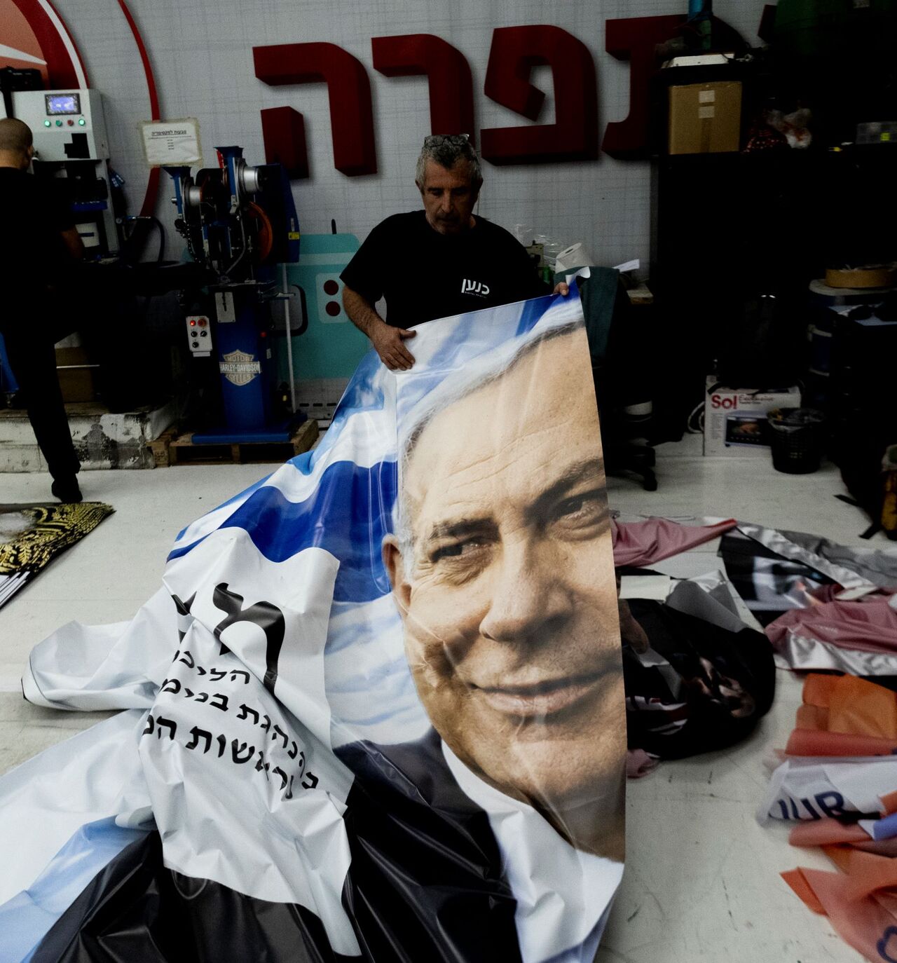 A print house worker produces a campaign poster showing Israeli Prime Minister Benjamin Netanyahu