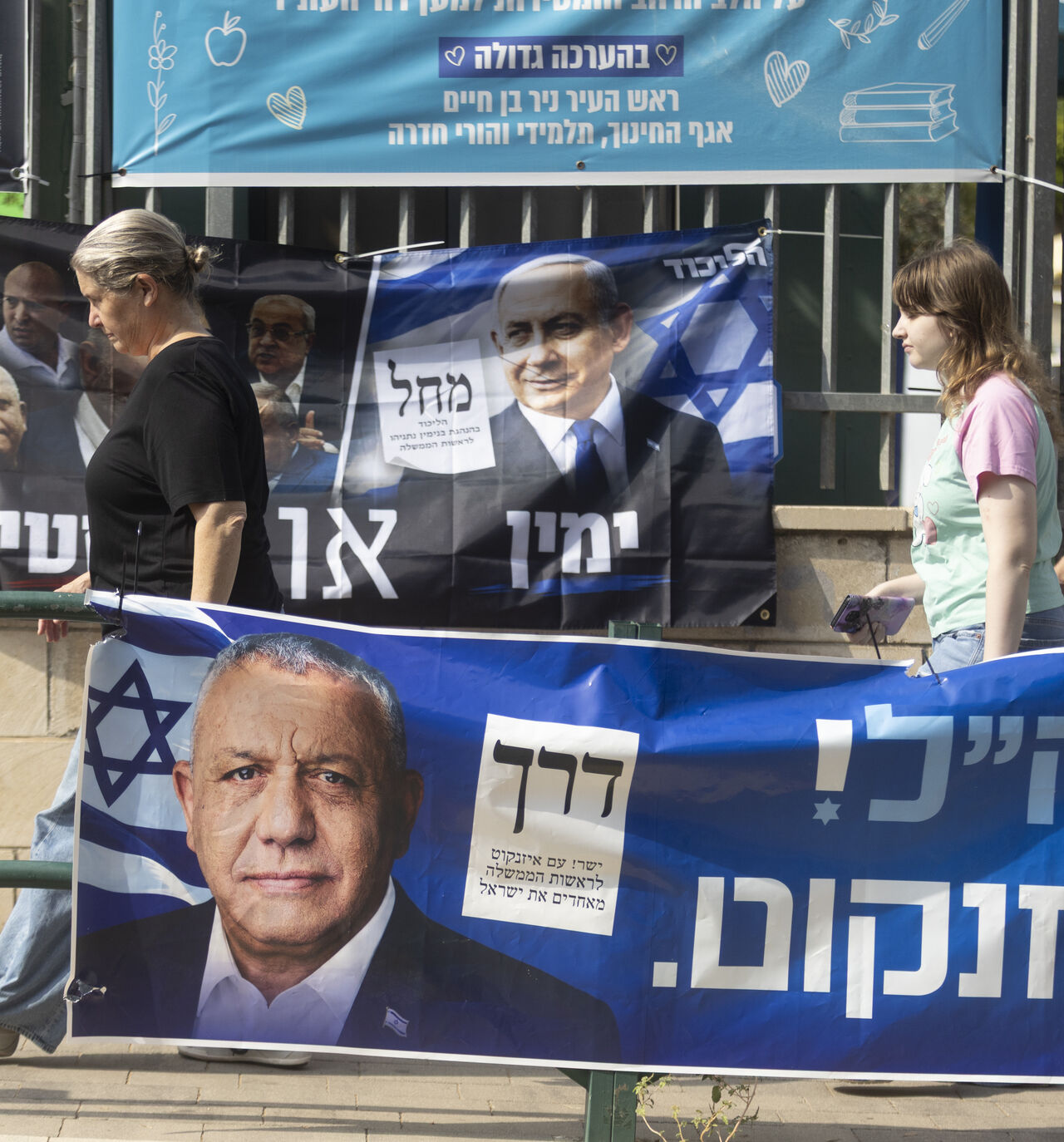 Israelis pass by campaign posters featuring Israeli Prime Minister, Benjamin Netanyahu, and Yashar Party leader, Gadi Eisenkot, near a polling station during Israel's general elections on October 27, 2026 in Hadera, Israel.