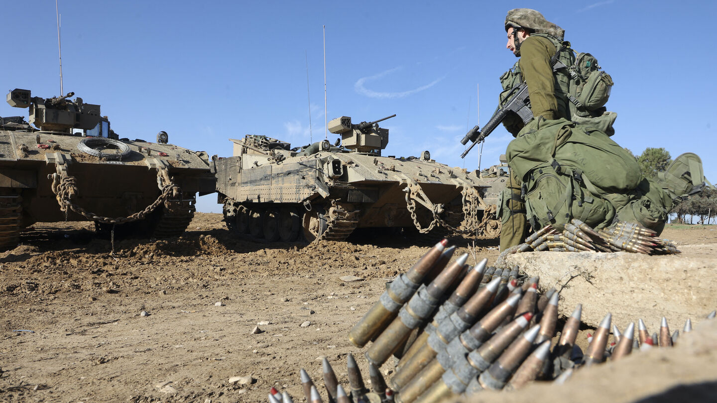 An Israeli soldier walks next to an armed APC (Armed Personnel Carrier) in southern Israel near the border with the Gaza Strip on November 30, 2023, as a truce between Israel and Hamas enters its seventh day. A truce between Israel and Hamas was extended on November 30 just before it was due to expire, the two sides announced, with mediator Qatar reporting it would continue for one day under the same conditions that saw hostages released in exchange for prisoners. (Photo by GIL COHEN-MAGEN / AFP) (Photo by 