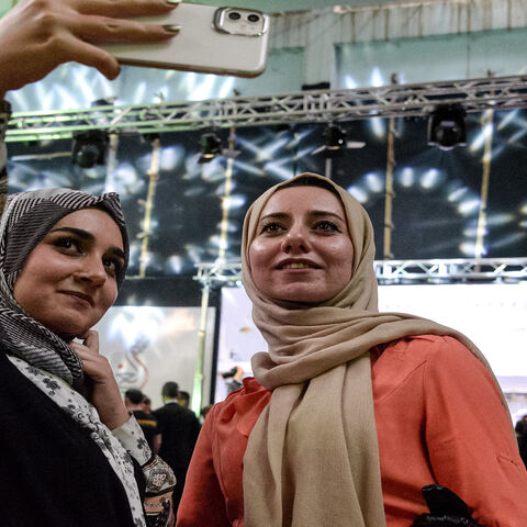 Women pose for a selfie after attending a performance by the Watar orchestral ensemble playing for the first time at the Spring Theater Hall, which was ravaged in the aftermath of the occupation by the Islamic State, Mosul, Iraq, April 8, 2021. 