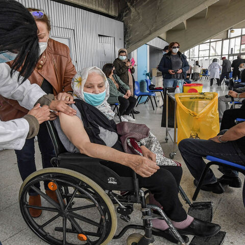 An elderly wheelchair-bound woman receives a dose of the Pfizer-BioNTech coronavirus vaccine at El-Menzah sports hall, Tunis, Tunisia, April 12, 2021.