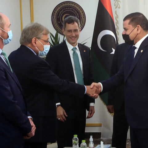 Libyan Prime Minister Abdulhamid Dbeibeh (R) shakes hands with a US State Department official as senior official Joey Hood (C) watches, during a visit by US officials to Libya in a show of support for the country's transitional government, Tripoli, Libya, May 18, 2021.