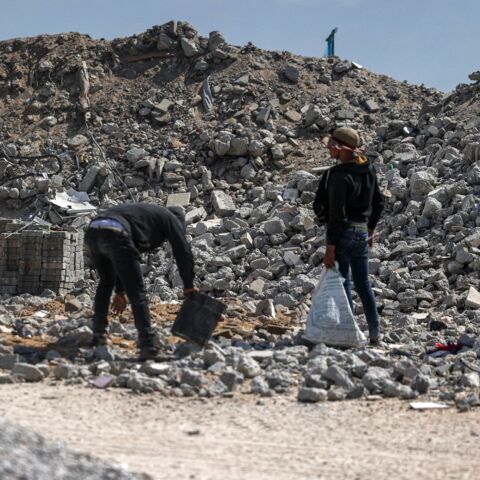 Workmen break rubble into pieces as they recycle salvaged construction materials from buildings destroyed during the May 2021 conflict between Hamas and Israel, at a rubble collection area in Gaza City's eastern suburb of Shujaiya on June 5, 2021.