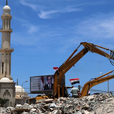 Egyptian workers and bulldozers sent from Egypt help on June 8, 2021, remove the rubble of buildings destroyed by Israeli airstrikes last month in Gaza City. 