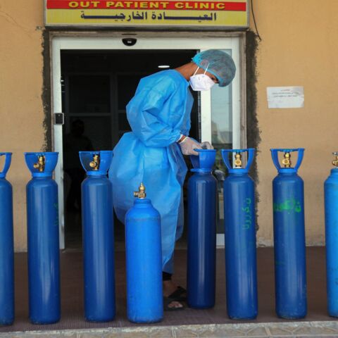 An Iraqi medic picks an oxygen bottle for a COVID-19 patient at a hospital in the northern Iraqi city of Dohuk.