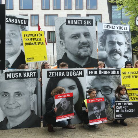Activists, including supporters of Reporters Without Borders and Amnesty International, hold up the photos of journalists, including Turkish-German journalist Deniz Yuecel, who are currently in prison in Turkey.