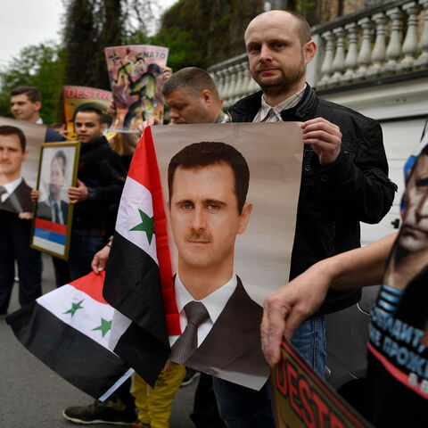 Protesters hold Syrian flags, posters and pictures of late Serbian strongman Slobodan Milosevic and Syrian President Bashar al-Assad, as they demonstrate against Western airstrikes against the Syrian regime, Belgrade, Serbia, April 15, 2018.