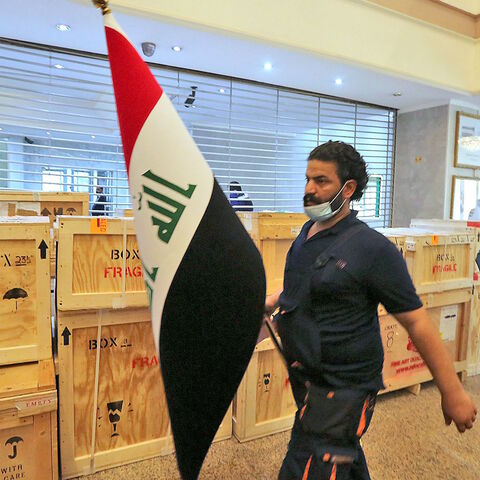 Staff members at Iraq's Ministry of Foreign Affairs work around crates of looted Iraqi antiquities returned by the United States, ahead of a handover ceremony at the ministry in the capital Baghdad, on Aug. 3, 2021. 
