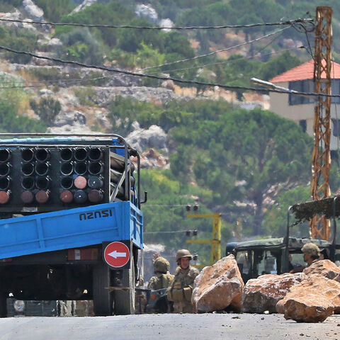 Lebanese soldiers stand next to a truck carrying a multiple rocket launcher after confiscating it