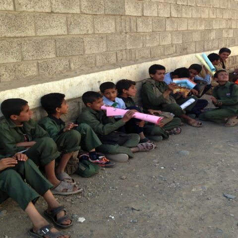 Yemeni school children sit outside their school on Sept. 29, 2014, in the district of Chamlane in northern Sanaa. 