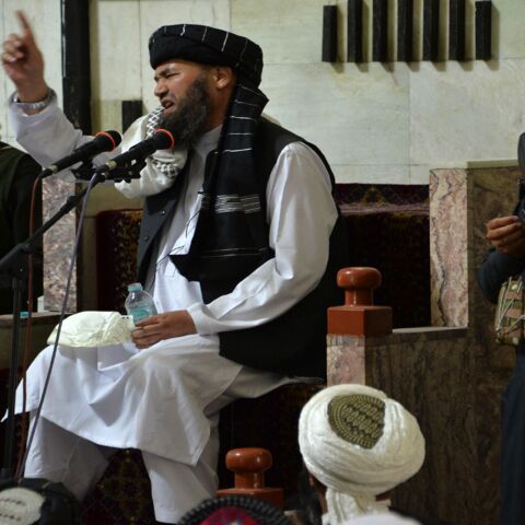 Armed Taliban fighters stand next to a mullah, a religious leader, speaking during Friday prayers at the Pul-e Khishti Mosque in Kabul on Sept. 3, 2021.