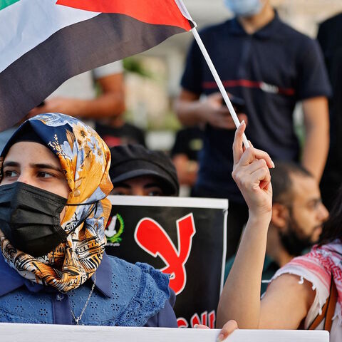 Arab Israeli protesters lift Palestinian flags and spoons, reportedly the digging tool used by six Palestinian prisoners who escaped from Israel's Gilboa prison, as they demonstrate in the mostly Arab city of Umm al-Fahm in northern Israel, on Sept. 10, 2021, to denounce punitive measures taken by the Israel Prison Service against Palestinian prisoners following the jailbreak. 
