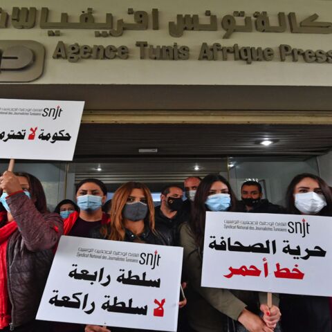 Journalists hold up signs reading in Arabic (R to L) "freedom of the press is a red line."