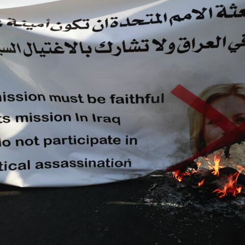 Supporters of the pro-Iran Hashid al-Shaabi alliance burn a banner bearing a crossed portrait of the special representative of the UN secretary-general's Assistance Mission for Iraq Jeanine Hennis-Plasschaert.