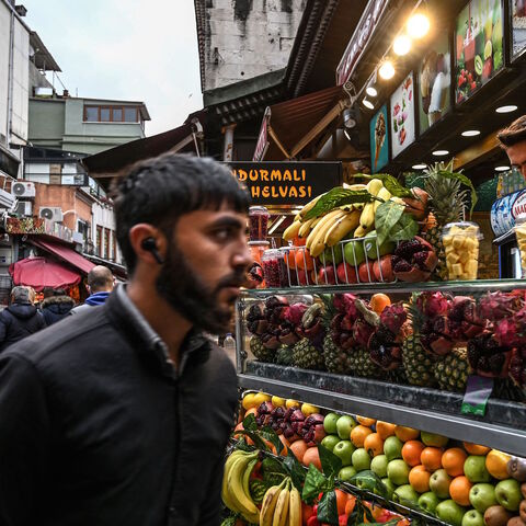 A man walks past a fruit seller at Eminonu district near Spice Bazaar in Istanbul, on Nov. 24, 2021. 