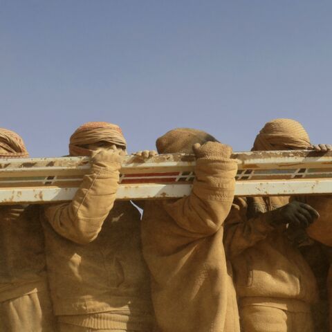Men standing in the back of a truck after fleeing battles between SDF and IS in the Syrian village of Baghuz arrive after crossing a desert to a region controlled by the SDF in Deir ez-Zor on Jan. 26, 2019.