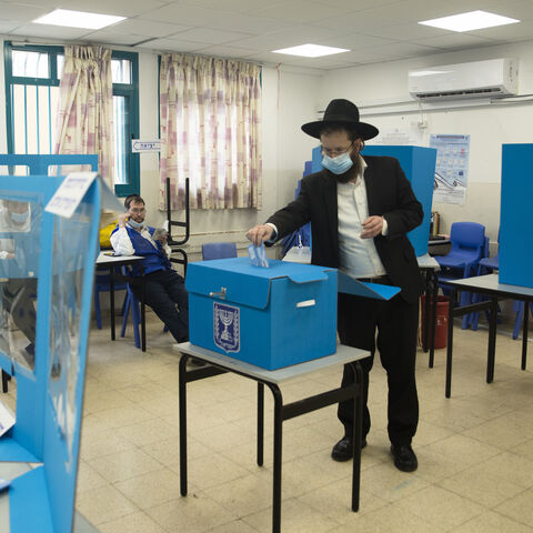 An Orthodox Jewish man casts his vote as Israelis head to the polls on March 23, 2021 in Bnei Brak, Israel.