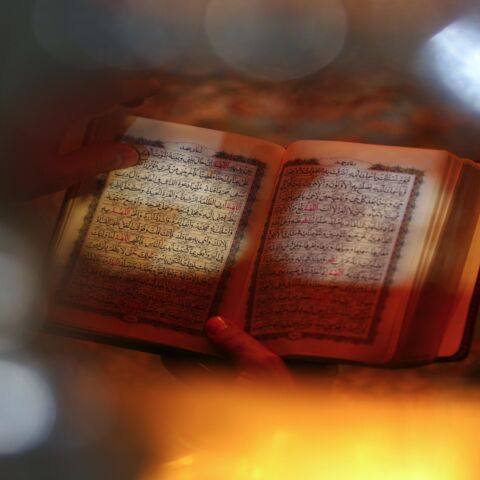 Worshippers read the Quran during prayer rituals at the Imam Ali shrine in the holy Iraqi city of Najaf, on May 1, 2021. 