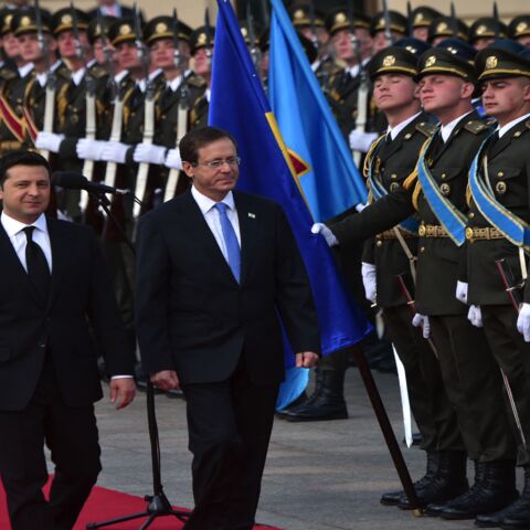 Ukrainian President Volodymyr Zelensky (L) and his Israeli counterpart, Isaac Herzog (C), review a guard of honor.