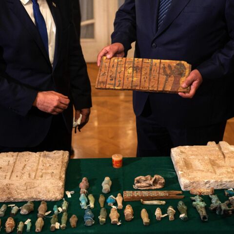 Israeli Foreign Minister Yair Lapid (L) presents Egypt's Foreign Minister Sameh Shoukry (R) with stolen Egyptian artifacts that were smuggled to Israel, at Tahrir Palace in Cairo on Dec. 9, 2021.