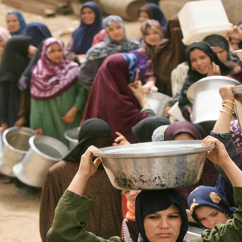 Egyptian women line up at a water cistern (unseen) to fill their containers with clean water at al-Rahawe village, some 40 kilometers (25 miles) northeast of Cairo, Egypt, May 27, 2010.