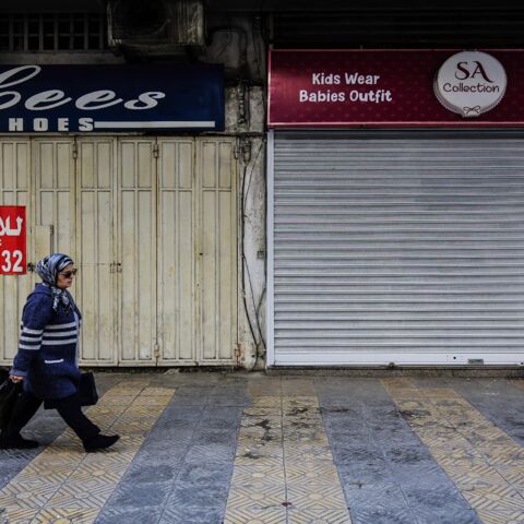 A Lebanese woman walks past closed stores in the northern city of Tripoli on Feb. 25, 2020.