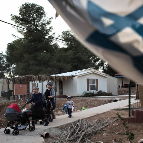 Members of the new Jewish community of Hiram walk with their children in their temporary village in Mahane Yatir located in the northern Negev Desert, Nov. 24, 2013.