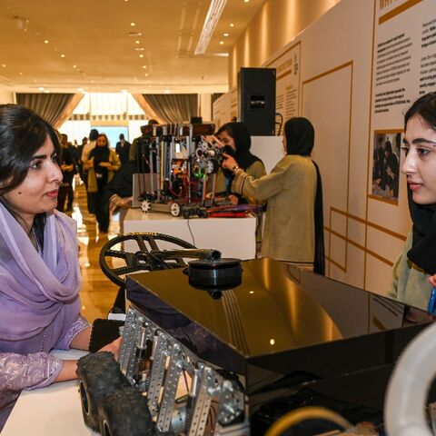 Malala Yousafzai speaks with member of the Afghan Girls Robotics Team at the Doha Forum in the Qatari capital