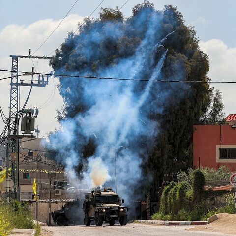 Tear gas canisters are fired from an Israeli military vehicle near the Palestinian refugee camp of Jenin in the occupied West Bank on April 9, 2022