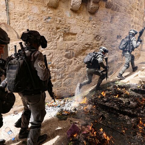 Israeli police pursue Palestinian protesters near Lion's Gate in Jerusalem's Old City on Sunday