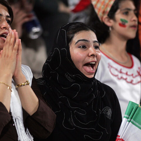 Iranian women, holding national flags, jubilate following their team's victory over Qatar at Doha's al-Gharrafa stadium during their World Cup 2006 qualifying match Oct. 13, 2004. 