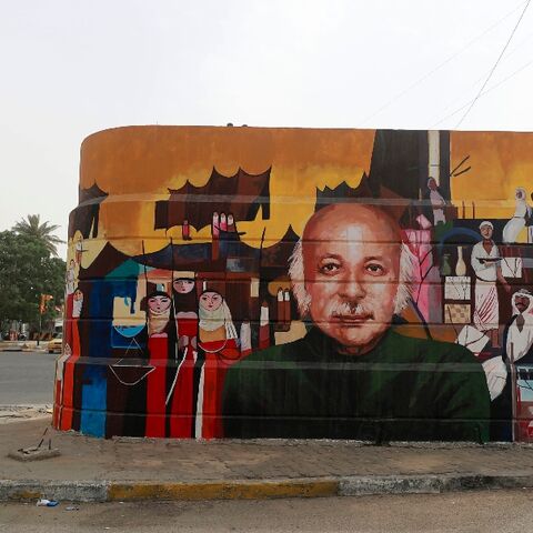 A policeman talks on the phone near a mural depicting Iraqi poet Muzzafar al-Nawab in Baghdad