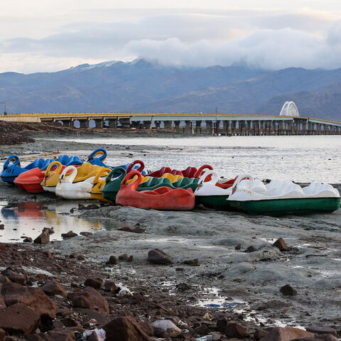 Recreational boats along the shore of the salt lake of Urmia and Shahid Kalantari causeway crossing it in Iran.