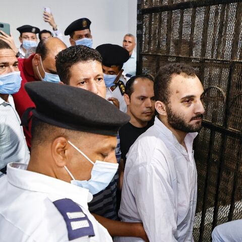 Mohamed Adel (C) is surrounded by guards after his first trial session at the Mansoura courthouse on June 26, 2022. He was sentenced to death on Tuesday for the murder of student Nayera Ashraf
