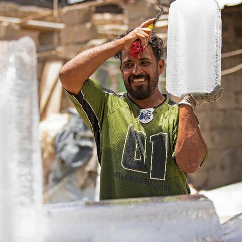 A man carries a block of ice at his stall in Iraq's southern city of Basra