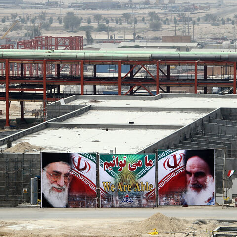 A huge banner bearing portraits of Iran's supreme leader Ayatollah Ali Khamenei (L) and his predecessor, the founder of the Islamic republic, Ayatollah Ruhollah Khomeini (R), is seen on a building being constructed at phase 15 and 16 of South Pars gas field development in the southern Iranian port town of Asaluyeh on July 19, 2010 as a top official announced that global energy majors are welcome to help develop oil and gas projects in Iran despite new sanctions imposed on the Islamic republic. AFP PHOTO/ATT