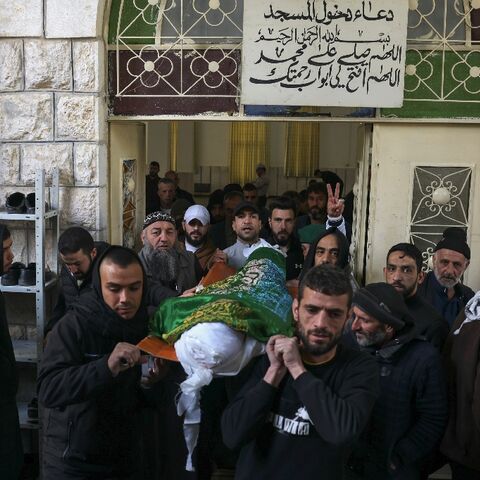 Palestinians carry the body of Nassim Abu Fouda who was killed by Israeli security forces early in the morning, during his funeral in Hebron city in the occupied West Bank, on January 30, 2023