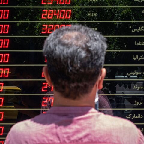 An Iranian man looks looks at currency exchange rates outside a shop in downtown Tehran on June 15, 2021. - Iran holds a presidential election on June 18, with ultraconservative Ebrahim Raisi, who heads the judiciary, most likely to win from the seven candidates. (Photo by MORTEZA NIKOUBAZL / AFP) (Photo by MORTEZA NIKOUBAZL/AFP via Getty Images)