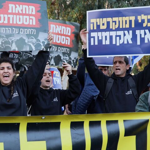 Israeli protesters hold placards reading in Hebrew "Israeli students fighting for democracy"(L) and "There is no academy as tool of democracy(R) during a demonstration against controversial government plans to give lawmakers more control of the judicial system, in Tel Aviv on January 26, 2023. - Prime Minister Benjamin Netanyahu and his allies, who have formed the most right-wing government in Israel's history, say the reforms are necessary to correct an imbalance that has given judges too much power over e