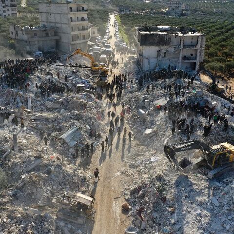 An aerial view of rescuers searching the rubble in the village of Besnaya in northwest Syria
