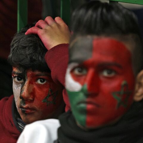 Palestinian football fans in Gaza watch Morocco's team play during the 2022 World Cup on December 14, 2022, with their faces painted in the Moroccan and Palestinian flags