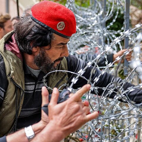 Protesters try to remove the barbed wire fence outside the government palace headquarters in the centre of Beirut