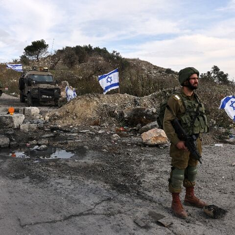 Israeli soldiers guard the road leading to the Homesh Yeshiva (religious school), at the former settlement of Homesh, December 30, 2021