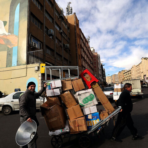 A man pulls a cart loaded with boxes in Tehran on February 21, 2023. - Iran's currency plunged to new lows on January 20 amid fresh European Union sanctions, crossing the psychologically important rate of 500,000 rials to a dollar in foreign exchange markets. (Photo by ATTA KENARE / AFP) (Photo by ATTA KENARE/AFP via Getty Images)